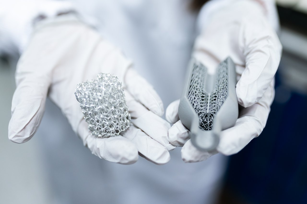 Crafting Captivating Headlines: Your awesome post title goes here Laboratory setting showing gloved hands holding innovative 3D printed metal structures.